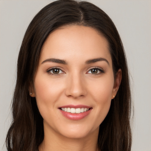 Joyful white young-adult female with long  brown hair and brown eyes