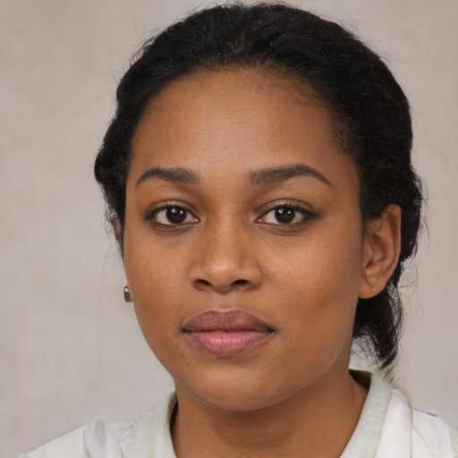 Joyful black young-adult female with short  black hair and brown eyes