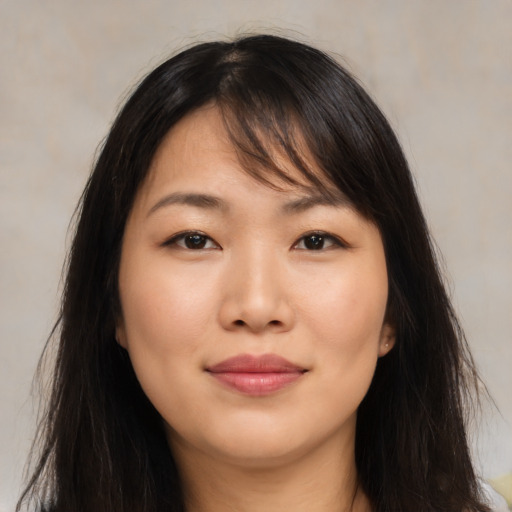 Joyful asian young-adult female with long  brown hair and brown eyes