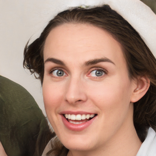 Joyful white young-adult female with medium  brown hair and grey eyes