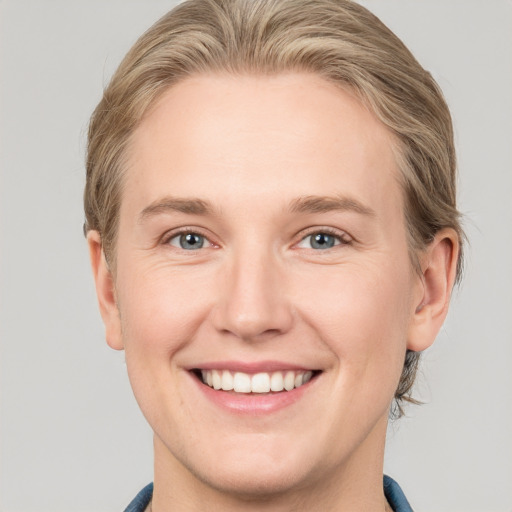 Joyful white young-adult female with medium  brown hair and blue eyes