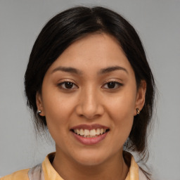 Joyful latino young-adult female with medium  brown hair and brown eyes