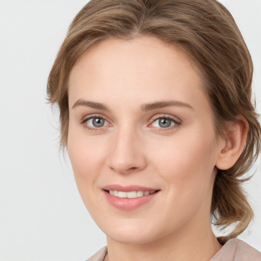 Joyful white young-adult female with medium  brown hair and green eyes