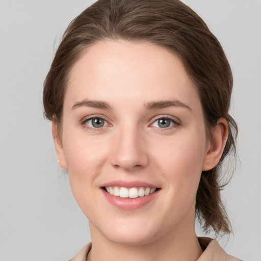 Joyful white young-adult female with medium  brown hair and grey eyes