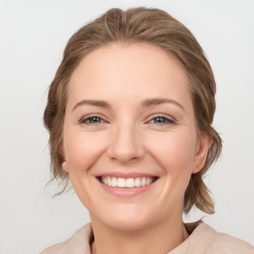 Joyful white young-adult female with medium  brown hair and grey eyes