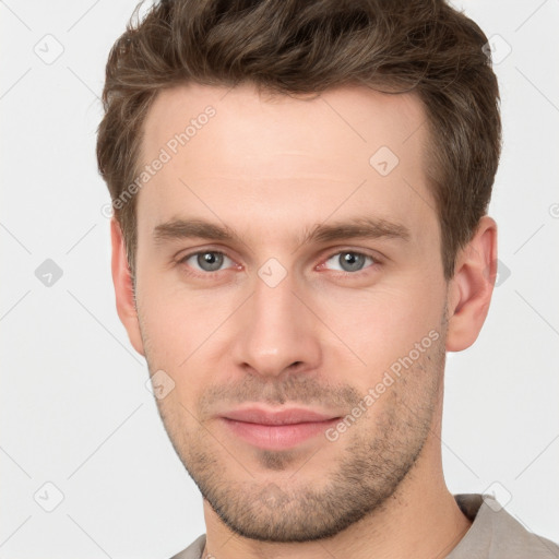 Joyful white young-adult male with short  brown hair and grey eyes