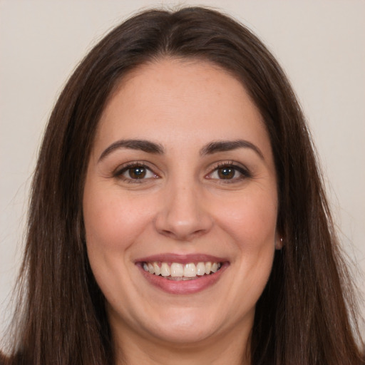 Joyful white young-adult female with long  brown hair and brown eyes