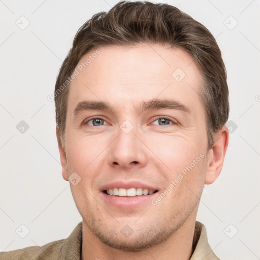 Joyful white young-adult male with short  brown hair and grey eyes