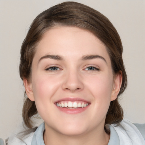 Joyful white young-adult female with medium  brown hair and blue eyes