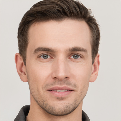 Joyful white young-adult male with short  brown hair and grey eyes