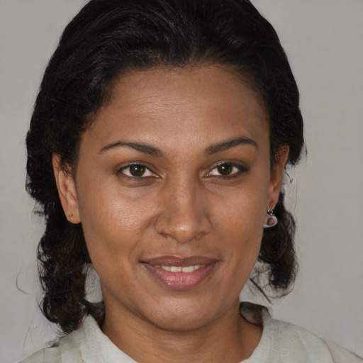 Joyful black adult female with medium  brown hair and brown eyes