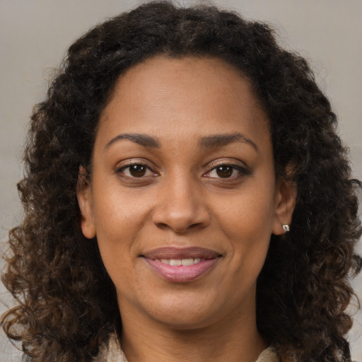 Joyful black adult female with medium  brown hair and brown eyes