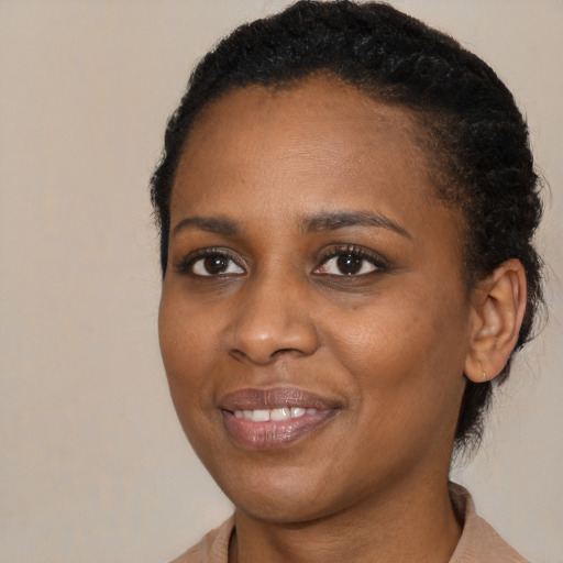 Joyful black young-adult female with medium  black hair and brown eyes