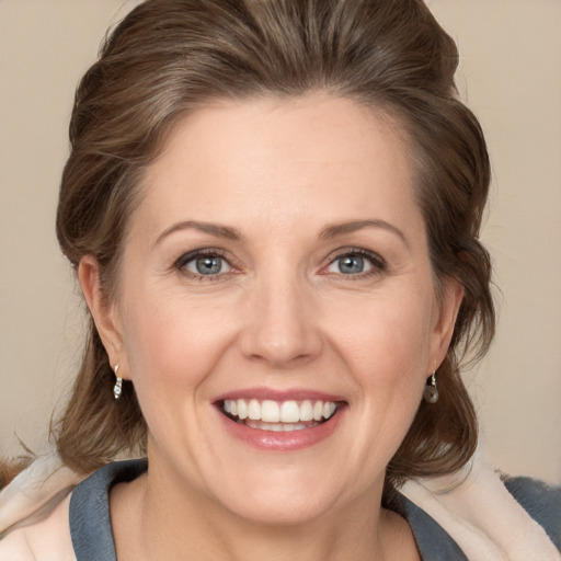 Joyful white adult female with medium  brown hair and grey eyes