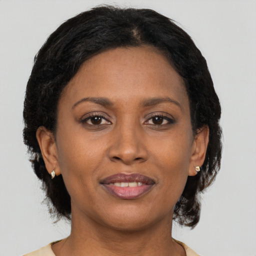 Joyful black adult female with medium  brown hair and brown eyes