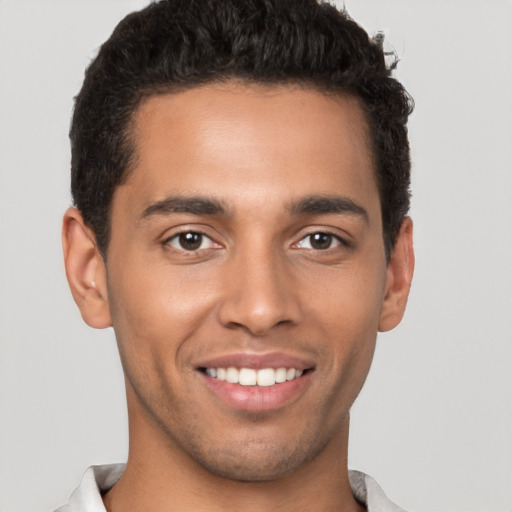 Joyful latino young-adult male with short  brown hair and brown eyes