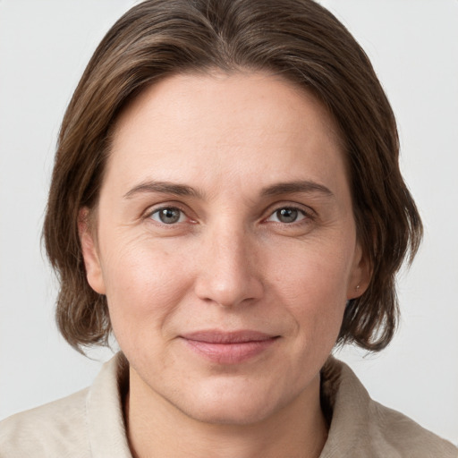 Joyful white adult female with medium  brown hair and grey eyes