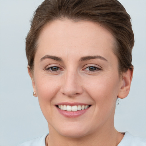 Joyful white young-adult female with short  brown hair and grey eyes