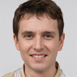 Joyful white young-adult male with short  brown hair and grey eyes