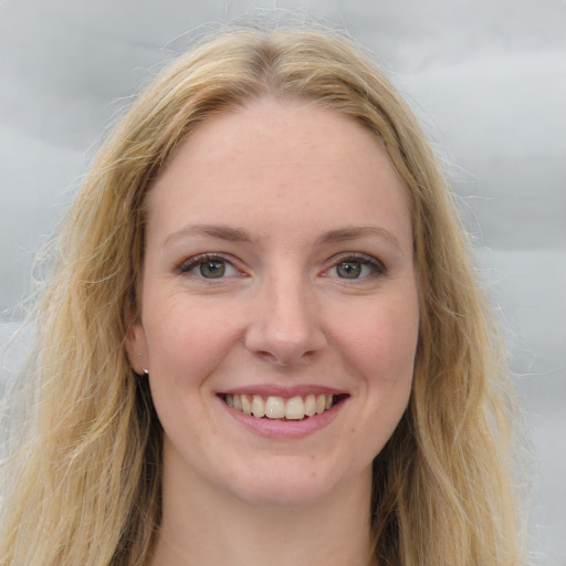 Joyful white young-adult female with long  brown hair and blue eyes