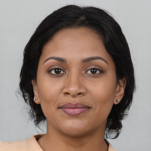 Joyful black adult female with long  brown hair and brown eyes