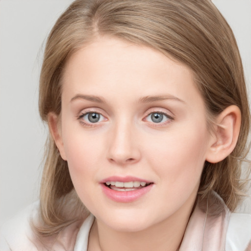 Joyful white young-adult female with medium  brown hair and blue eyes