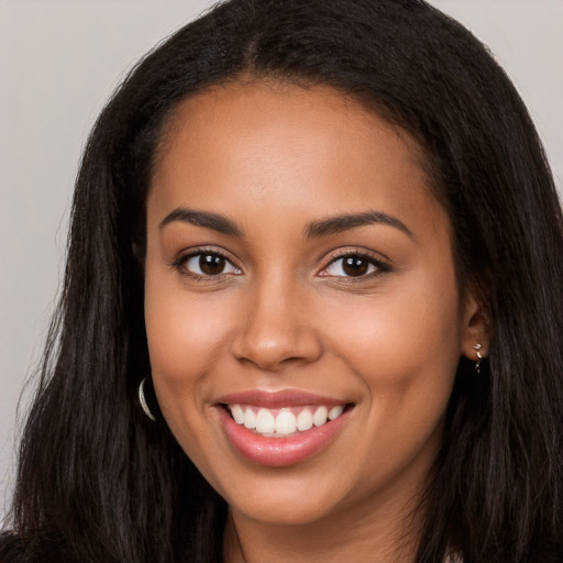 Joyful latino young-adult female with long  brown hair and brown eyes