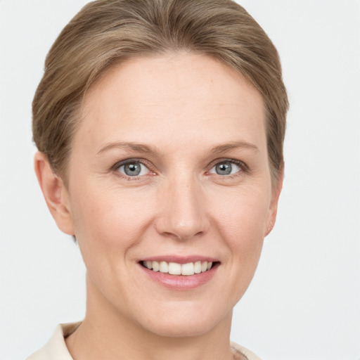 Joyful white young-adult female with short  brown hair and grey eyes