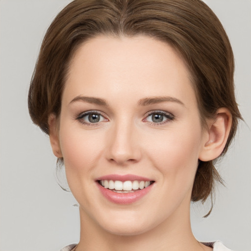 Joyful white young-adult female with medium  brown hair and grey eyes