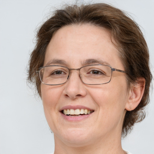 Joyful white adult female with medium  brown hair and green eyes