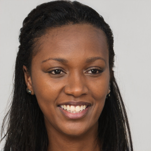Joyful black young-adult female with long  brown hair and brown eyes