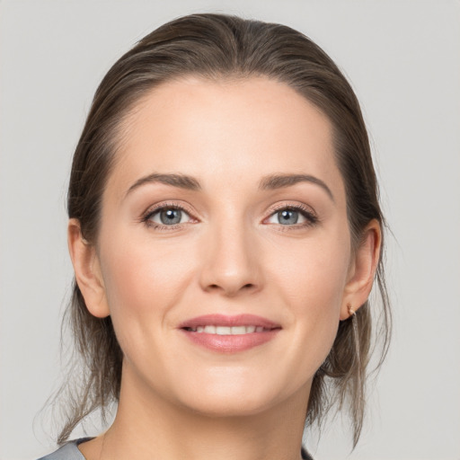 Joyful white young-adult female with medium  brown hair and grey eyes