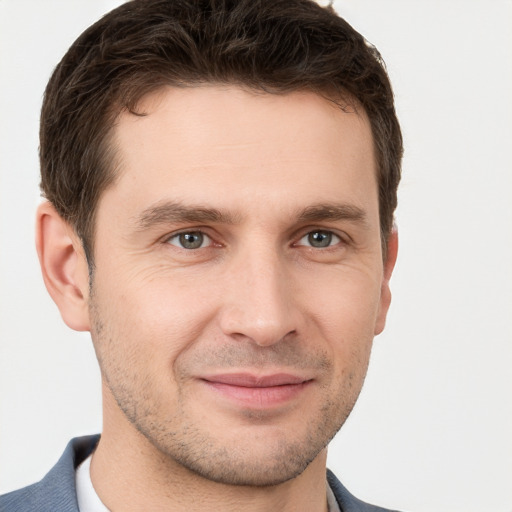 Joyful white young-adult male with short  brown hair and grey eyes