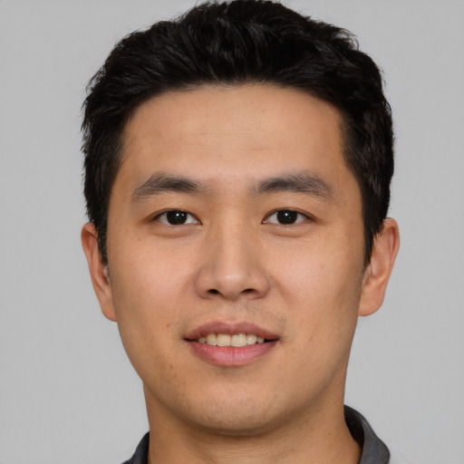 Joyful asian young-adult male with short  black hair and brown eyes