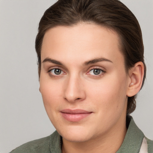 Joyful white young-adult female with medium  brown hair and grey eyes