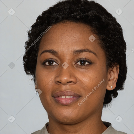 Joyful black young-adult female with short  black hair and brown eyes