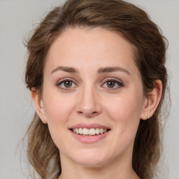 Joyful white young-adult female with medium  brown hair and green eyes