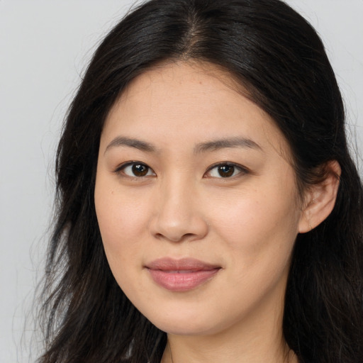 Joyful asian young-adult female with long  brown hair and brown eyes