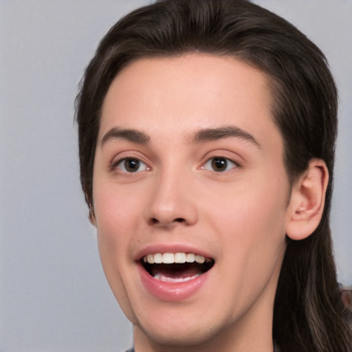 Joyful white young-adult male with long  brown hair and brown eyes