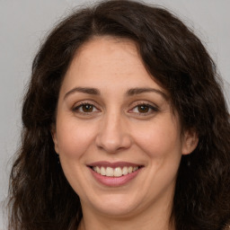 Joyful white adult female with long  brown hair and brown eyes