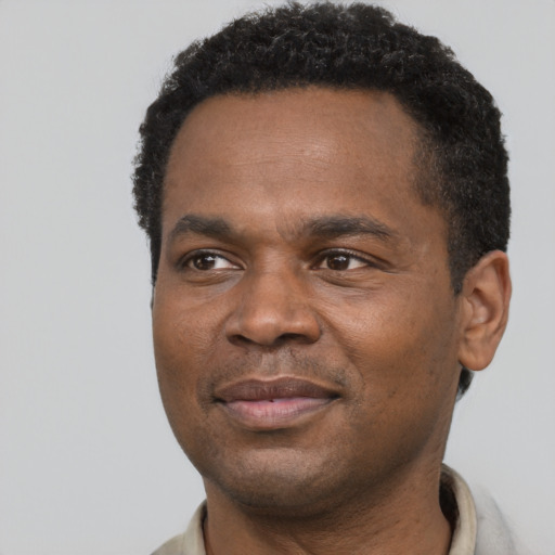 Joyful black adult male with short  black hair and brown eyes