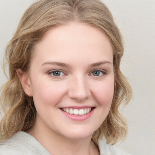 Joyful white young-adult female with medium  brown hair and blue eyes