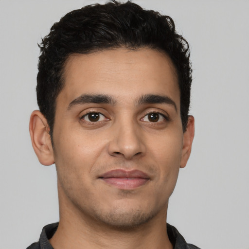 Joyful latino young-adult male with short  brown hair and brown eyes