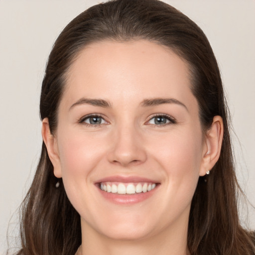 Joyful white young-adult female with long  brown hair and grey eyes