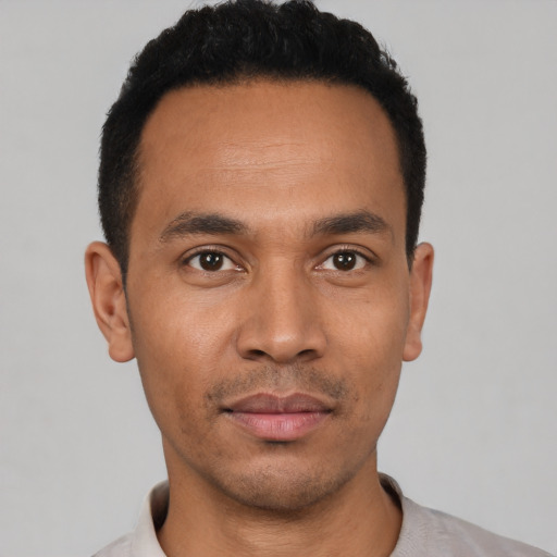 Joyful latino young-adult male with short  black hair and brown eyes