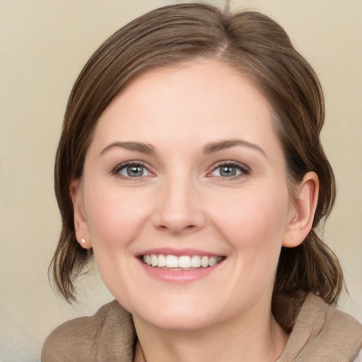 Joyful white young-adult female with medium  brown hair and green eyes