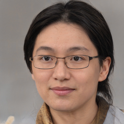Joyful asian adult female with medium  brown hair and brown eyes