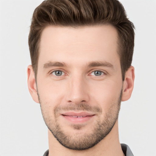 Joyful white young-adult male with short  brown hair and grey eyes