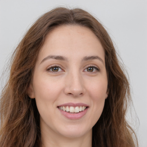 Joyful white young-adult female with long  brown hair and green eyes