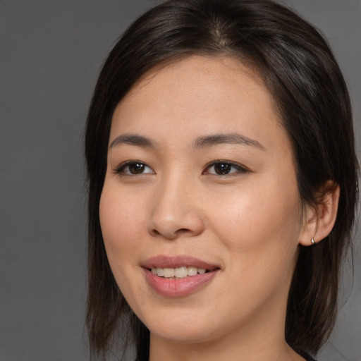 Joyful asian young-adult female with long  brown hair and brown eyes